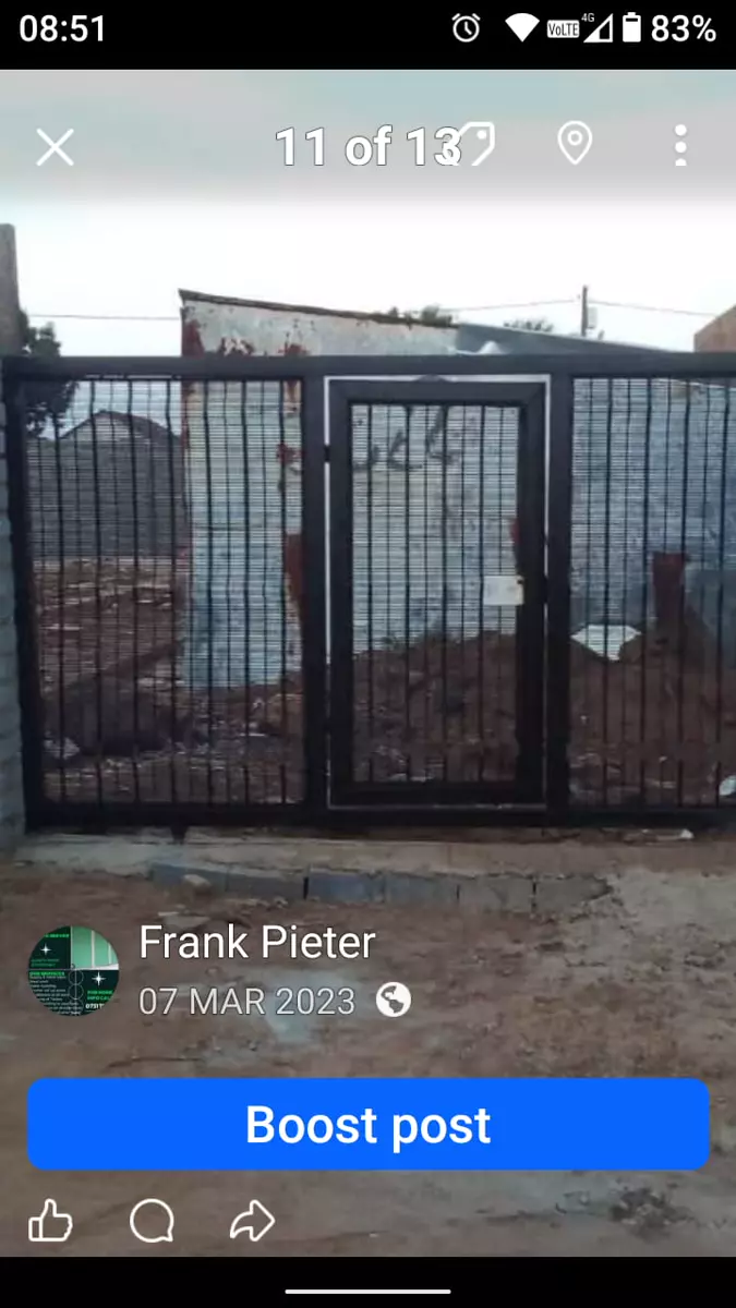 Black metal security gate with a pedestrian door