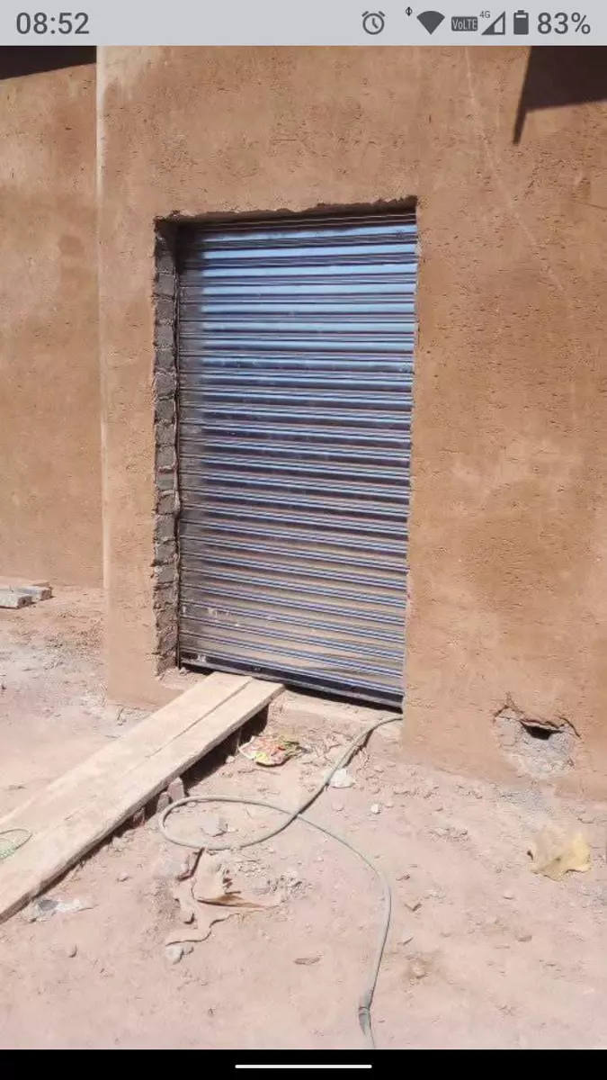 Metallic roller door fitted into a textured concrete wall