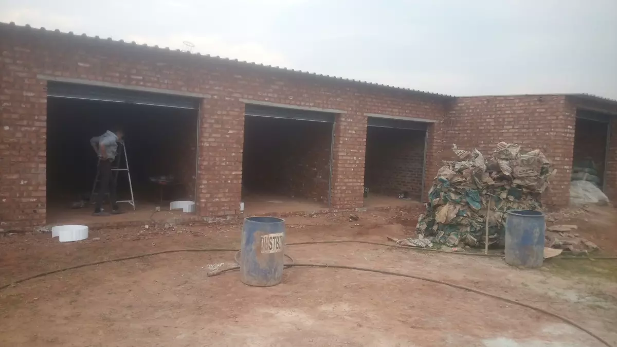 Brick building under construction with open garage doors
