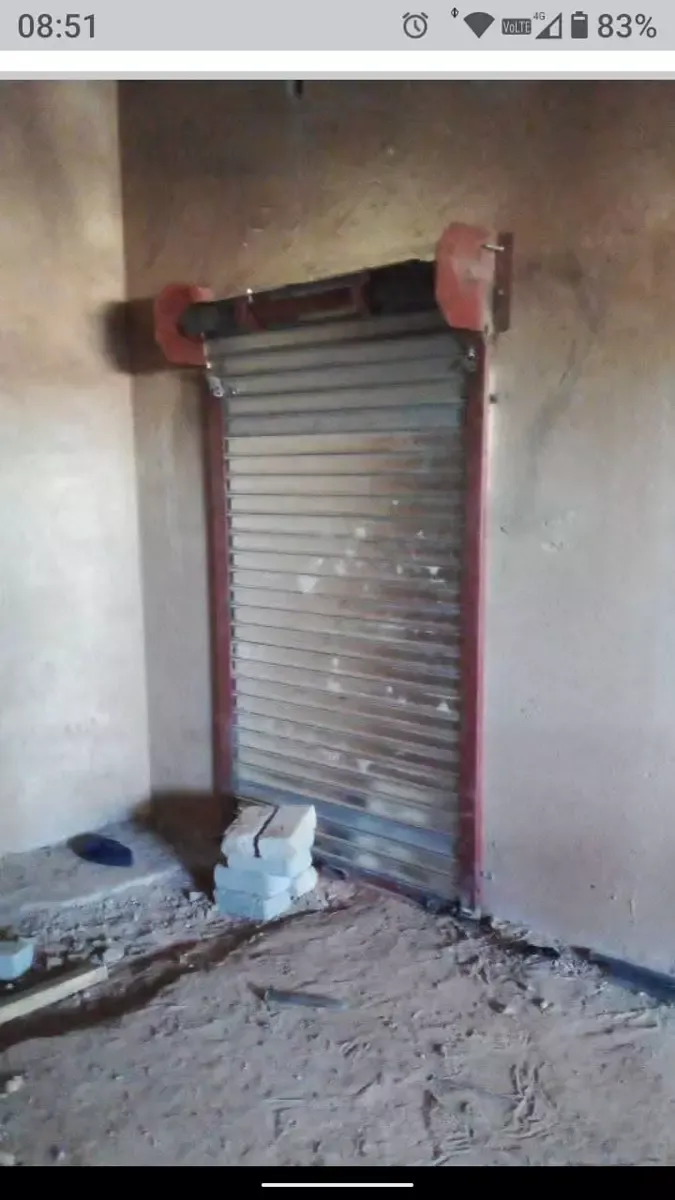 Metal roller shutter door installed in an unfinished concrete wall